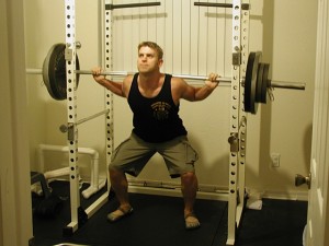 Drew Baye squatting in Vibram FiveFinger shoes